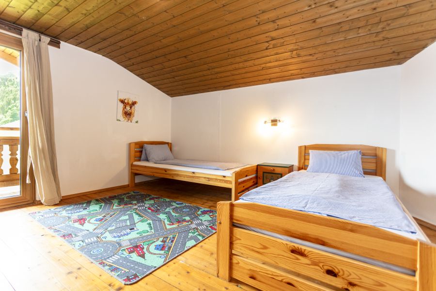 Kinderzimmer mit zwei Betten und Spielteppich