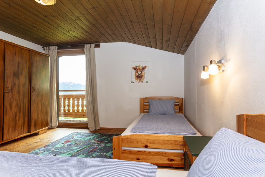 Schlafzimmer mit Holzbalkon in der Ferienwohnung Stoffenhof