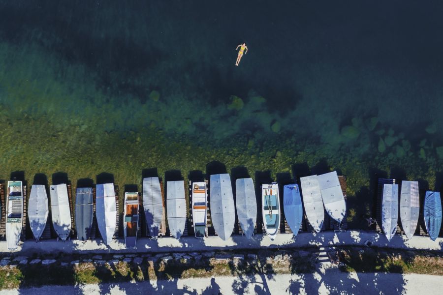 Schwimmer und Boote im klaren Wasser des Zeller Sees