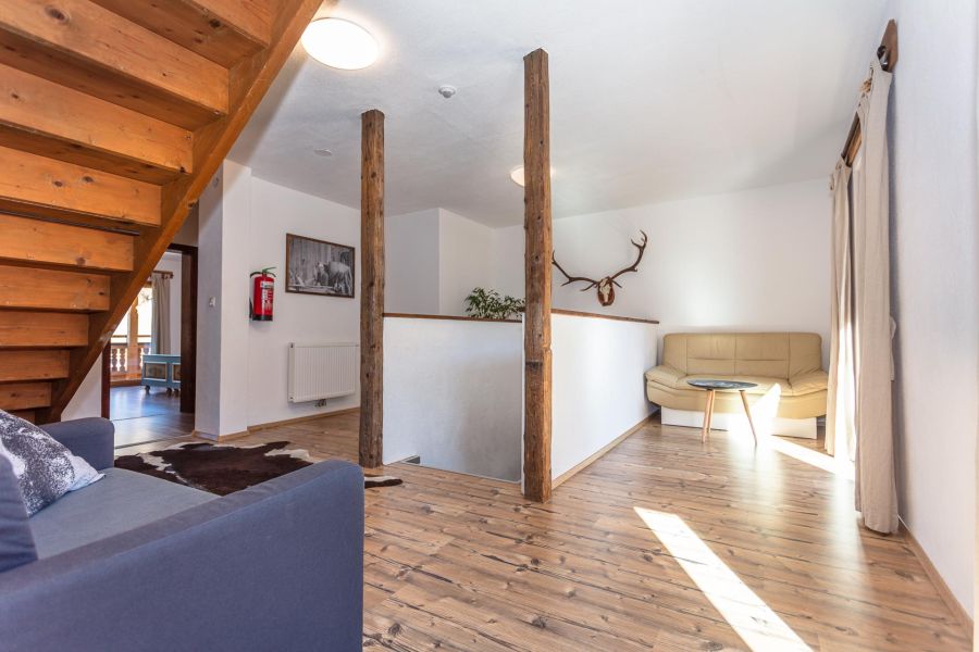Heller Wohnbereich mit Holztreppe in der Ferienwohnung Stoffenhof