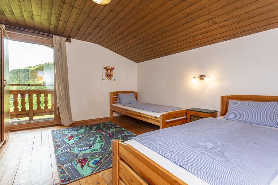 Schlafzimmer mit zwei Betten und Balkonzugang