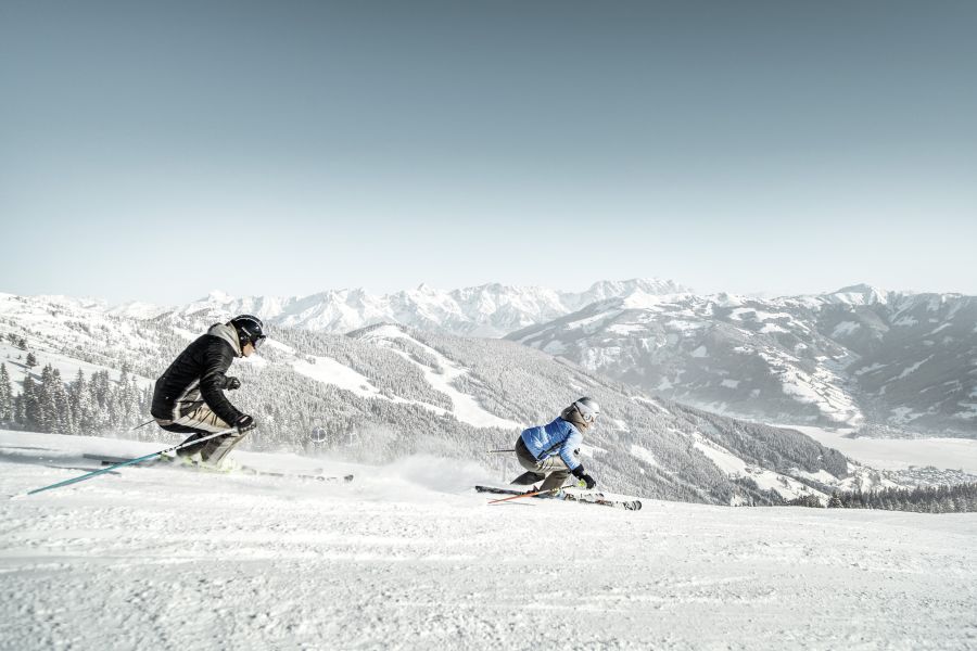 Skifahrer auf einer Abfahrt mit Blick auf den Zeller See