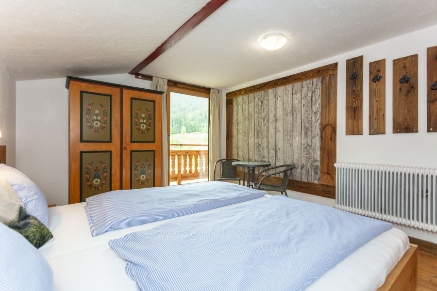 Doppelzimmer mit Holzschrank und Sitzecke