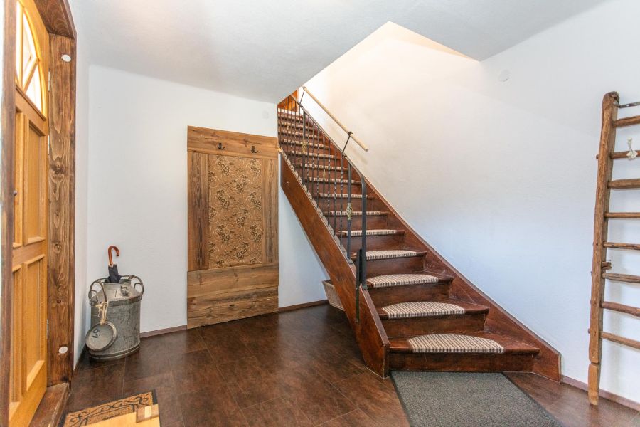 Flur mit Holztreppe und Garderobe in der Ferienwohnung Stoffenhof
